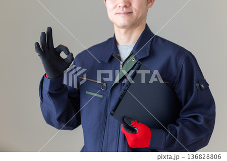 バインダーを持って丸サインをする作業服のミドル男性ビジネスマン 136828806