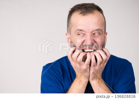Man biting his nails Man biting his nails 136828816