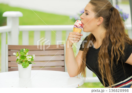 Young woman eating ice cream 136828998