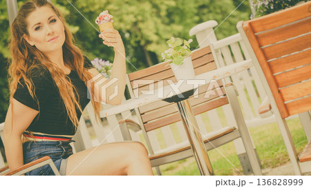 Young woman eating ice cream 136828999