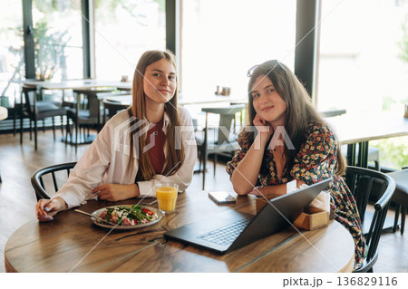 Two young women are together in the cafe restaurant Two young women are together in the cafe restaurant 136829116