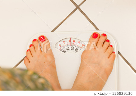 Woman feet on weighing scale Woman feet on weighing scale 136829136