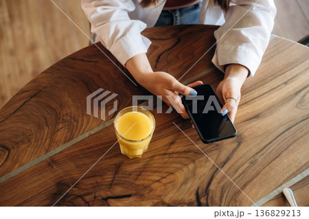 Orange juice. Close up view of teenage girl that is sitting in the cafe restaurant Orange juice. Close up view of teenage girl that is sitting in the cafe restaurant 136829213
