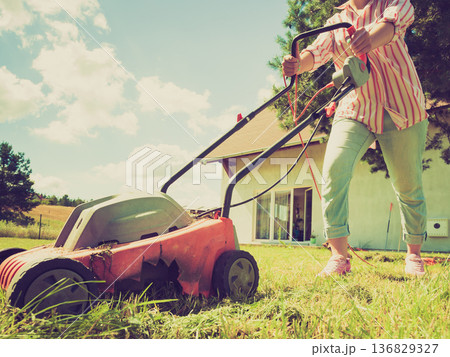 Person mowing green grass 136829327