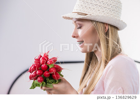 Young woman holding radish Young woman holding radish 136829629
