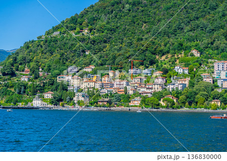 Como lake water in Summer day. Multicolor houses on green mountains Italian travel. Italy. Como lake water in Summer day. Multicolor houses on green mountains Italian travel. Italy. 136830000