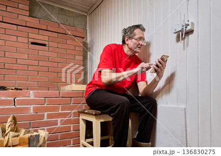 Homeowner searches internet for wifi router and repeater setup instructions using smartphone. 136830275