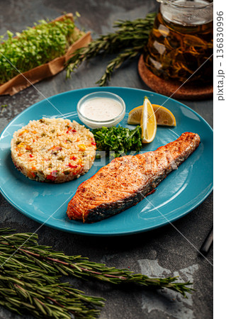 Salmon steak with rice and lemon 136830996