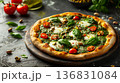 Artistic flat lay of green matcha pizza with red tomatoes contrasting against deep dark background, trendy restaurant menu concept 136831084
