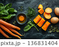 Healthy selection of foods high in vitamin A including fresh carrots, salmon fillet, eggs, avocado and pumpkin on dark backdrop 136831404