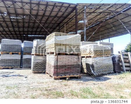 Tiles piled in pallets. Warehouse paving slabs in the factory for its production. 136831744