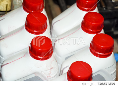 White plastic cans with red lids. Cans of transmission oil 136831839