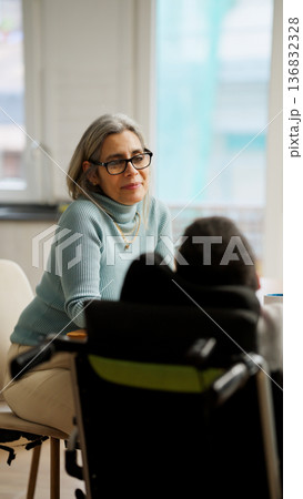 Woman communicating with person using a mobility aid 136832328