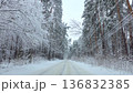 Car driving along snowy forest road in winter landscape 136832385