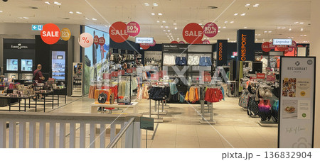 Berlin, Germany - August 27, 2025: Retail store interior with sale signs and colorful clothing displays Berlin, Germany - August 27, 2025: Retail store interior with sale signs and colorful clothing displays 136832904