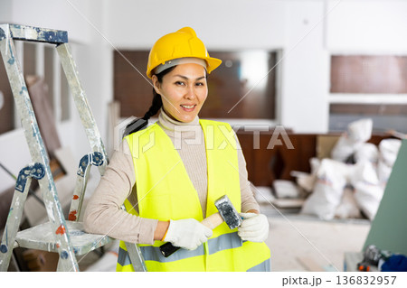 Portrait of positive woman builder standing in apartment Portrait of positive woman builder standing in apartment 136832957