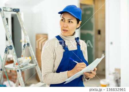 Portrait of an asian builder woman who checks completed work on 136832961