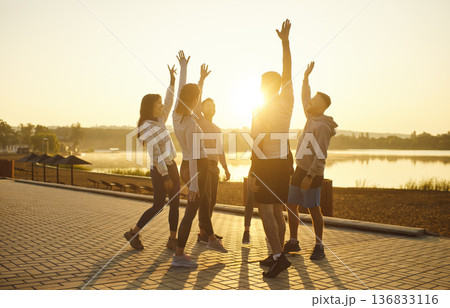 Runners celebrate end of morning marathon challenge with hands up and laughter Runners celebrate end of morning marathon challenge with hands up and laughter 136833116