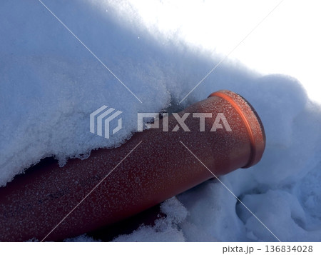 Red Sewer Pipe Covered in Snow on a Winter Day in an Outdoor Setting Red Sewer Pipe Covered in Snow on a Winter Day in an Outdoor Setting 136834028