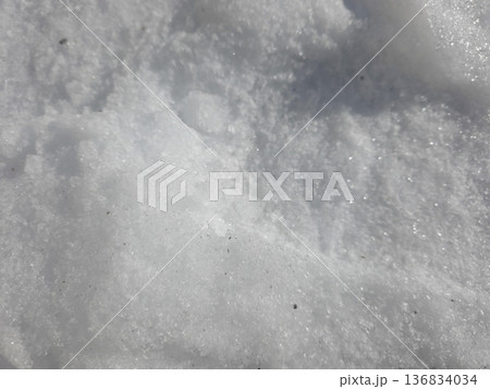 Snow Texture Shows Details of Winter Landscape Under Bright Sunlight 136834034
