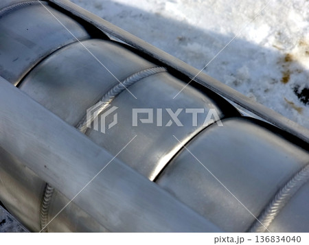 Stainless Steel Artesian Pump Housing Details Shown Against a Snowy Background 136834040