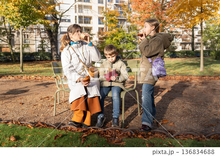 Family enjoying picnic snacks on sunny autumn day in park in France Family enjoying picnic snacks on sunny autumn day in park in France 136834688