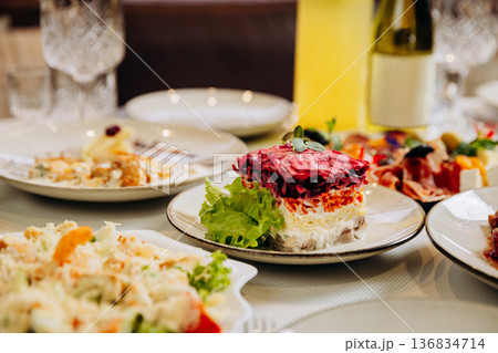 Traditional layered herring salad served on festive restaurant dinner table Traditional layered herring salad served on festive restaurant dinner table 136834714