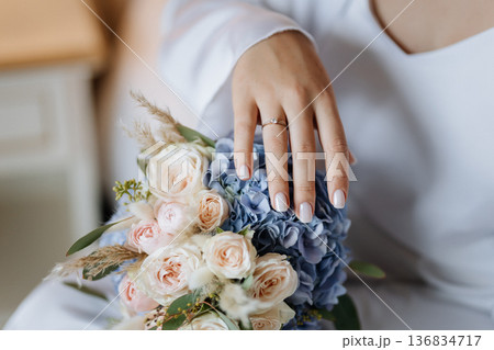 Bride hand with engagement ring on wedding bouquet, romantic close up detail Bride hand with engagement ring on wedding bouquet, romantic close up detail 136834717