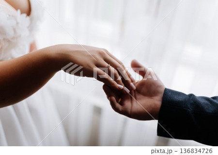 Bride and groom holding hands with wedding ring, romantic marriage moment close up Bride and groom holding hands with wedding ring, romantic marriage moment close up 136834726