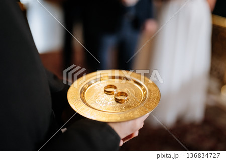 Wedding rings on golden plate during Orthodox church marriage ceremony ritual Wedding rings on golden plate during Orthodox church marriage ceremony ritual 136834727