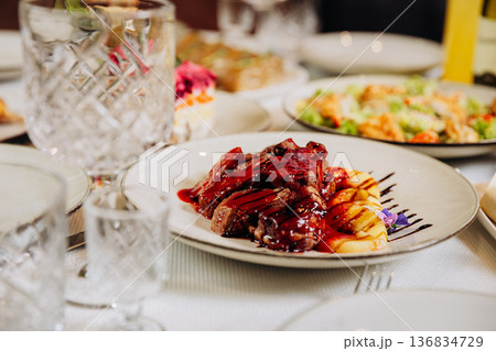 Grilled beef steak with berry sauce and potatoes served in elegant restaurant setting 136834729