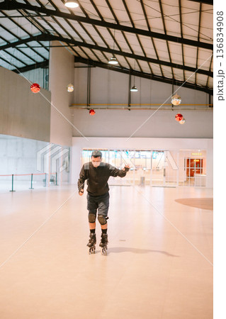 Adult Man Rollerblading in Spacious Modern Indoor Hall Adult Man Rollerblading in Spacious Modern Indoor Hall 136834908