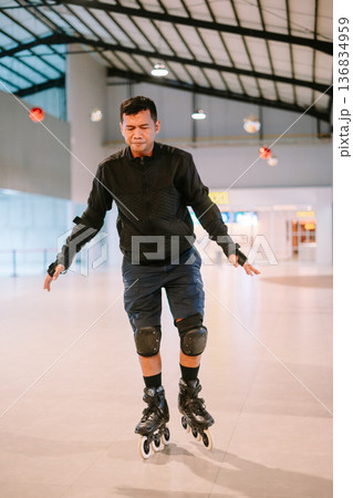Focused Adult Man Learning to Rollerblade Indoors 136834959