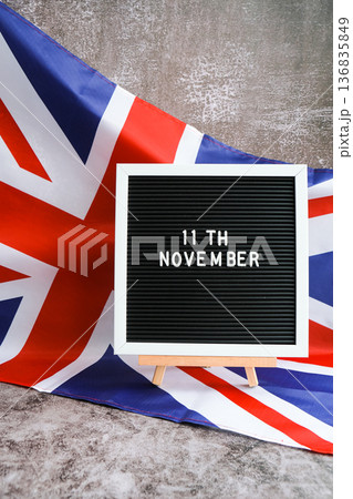 Minimal patriotic scene with signboard and waving flag date 11th November UNITED KINGDOM with national colors Festive background with British flag and message board with text Great Britain Minimal patriotic scene with signboard and waving flag date 11th November UNITED KINGDOM with national colors Festive background with British flag and message board with text Great Britain 136835849
