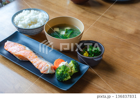 明るい自然光の食卓に並ぶ焼き鮭と味噌汁、ご飯、納豆の朝食 明るい自然光の食卓に並ぶ焼き鮭と味噌汁、ご飯、納豆の朝食 136837831