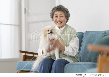 愛犬を抱くカメラ目線で笑顔のシニア女性　ポートレート 136839377