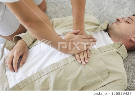 CPR, cardiopulmonary resuscitation and emergency help in breathing for lying man 136839427