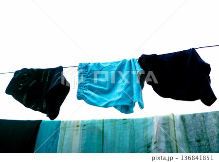 Clothes Drying on a Rope Against Blue Wall Outdoors Clothes Drying on a Rope Against Blue Wall Outdoors 136841851