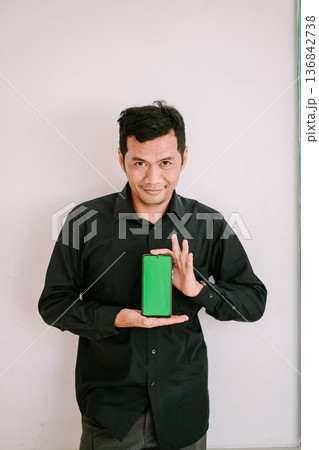 composite image of portrait of a handsome young man holding a book 136842738