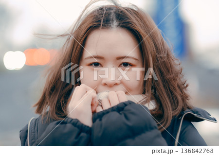 冬の夕暮れに思いにふける若い女性の屋外ポートレート 136842768