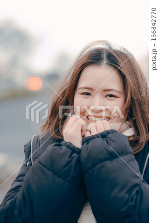 冬の夕暮れに思いにふける若い女性の屋外ポートレート 136842770