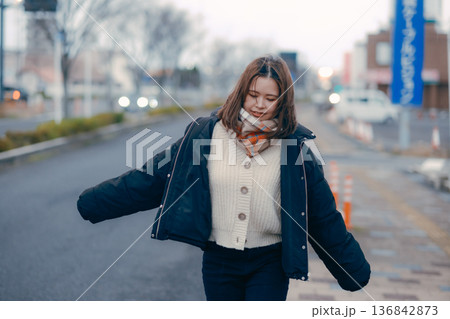 夕方の街を歩く若い女性 136842873