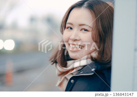 夕方の街で物思いにふける若い女性 136843147