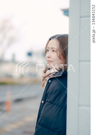 夕方の街で物思いにふける若い女性 136843152