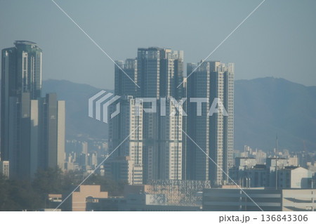 Hazy Korean City Skyline with Mountains and High Rise Apartments 136843306