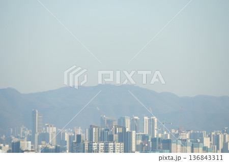 Hazy Korean City Skyline with Mountains and High Rise Apartments 136843311