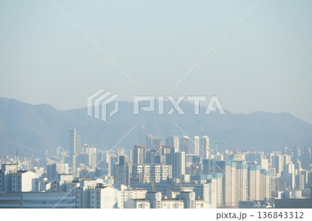 Hazy Korean City Skyline with Mountains and High Rise Apartments 136843312