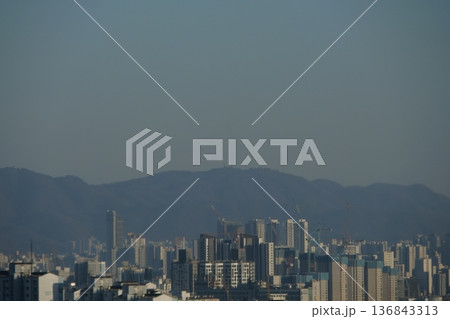 Hazy Korean City Skyline with Mountains and High Rise Apartments 136843313