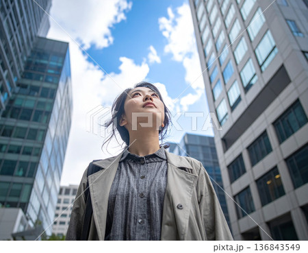 空を見上げるカジュアルな服装の女性、未来へのステップ 空を見上げるカジュアルな服装の女性、未来へのステップ 136843549