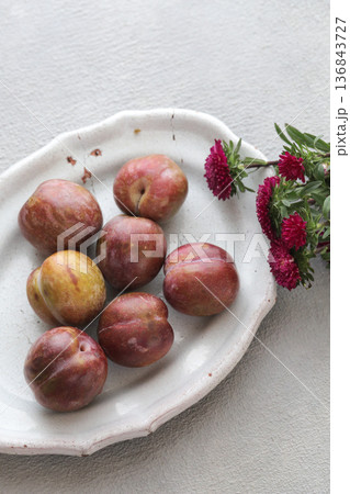 お皿に盛ったソルダムとお花 136843727